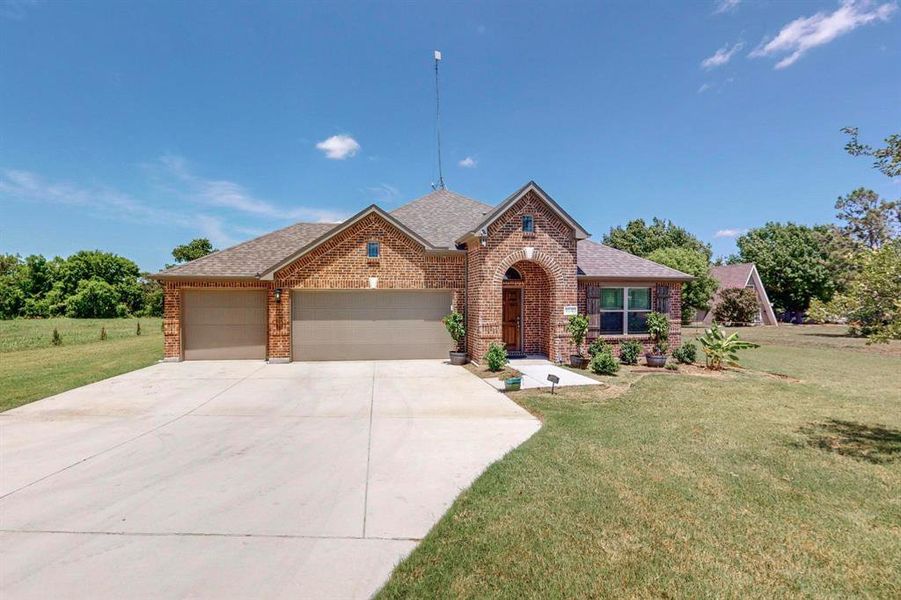 View of front of house with a garage and a front yard