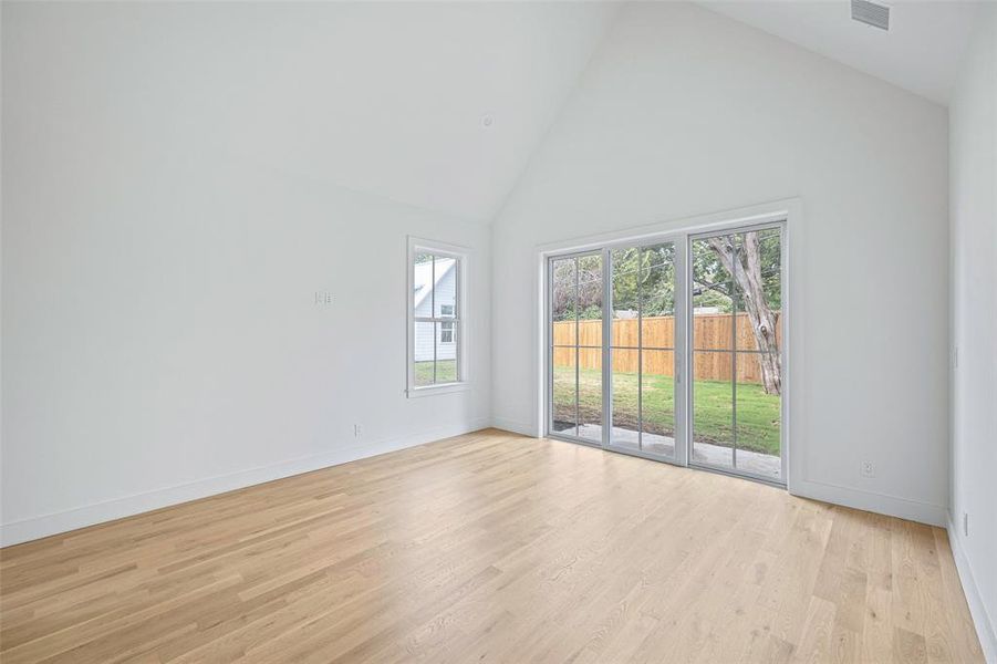 Primary Bedroom with vaulted celings and doors to the backyard