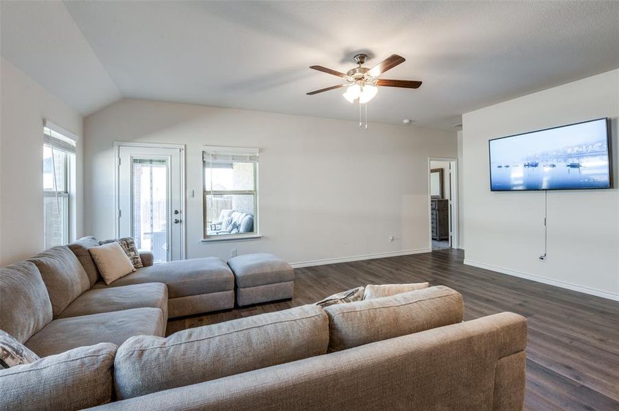 Living room featuring lofted ceiling, ceiling fan, and dark hardwood / wood-style flooring