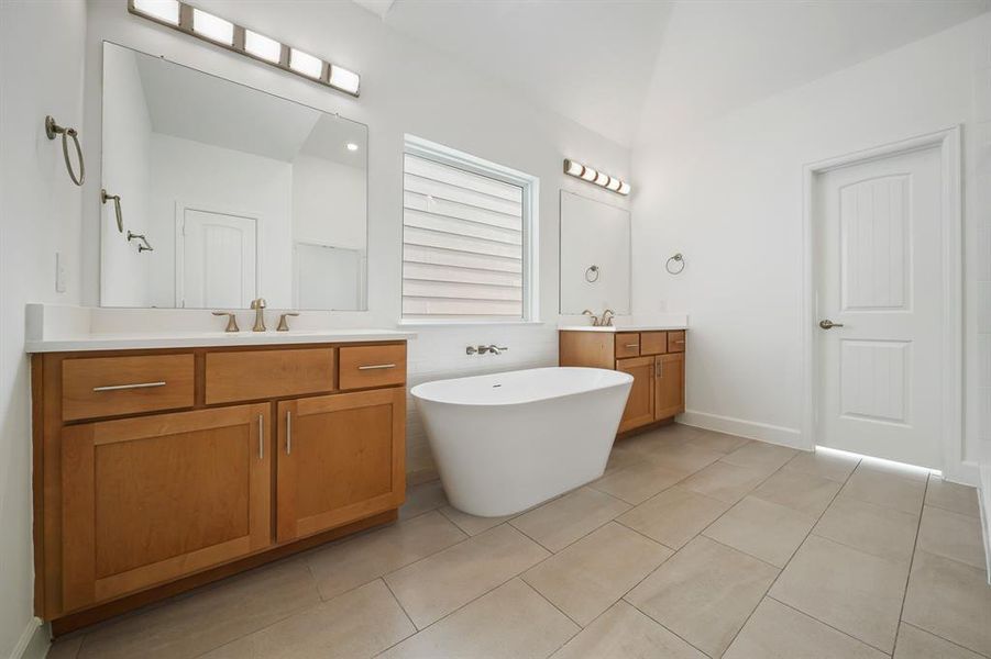 A view of the Primary Bathroom showing its dual vanities, spacious layout, custom cabinets, and quartz countertops. (Sample photos of a completed Lisbon floor plan. The image may feature alternative selections and/or upgrades.)