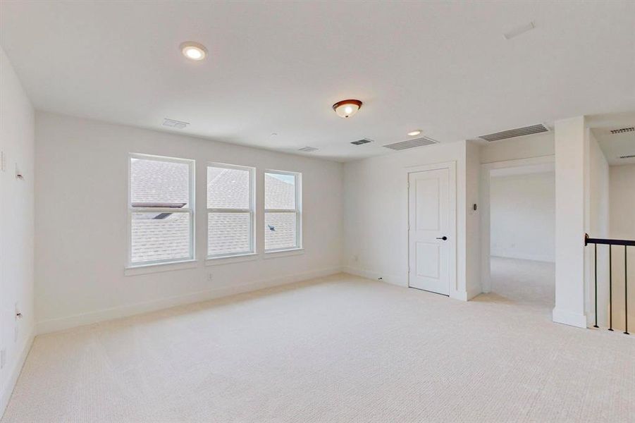 Unfurnished room with light carpet and plenty of natural light