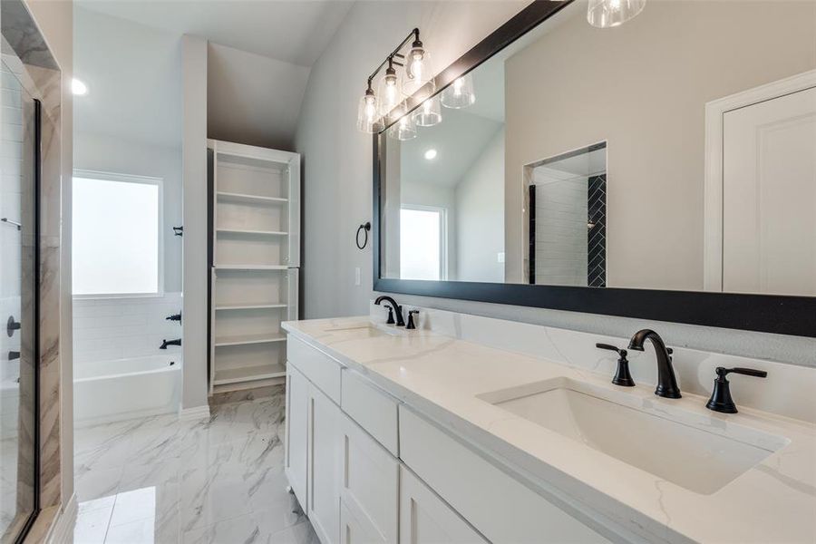 Bathroom with vanity, vaulted ceiling, towel storage and separate shower and tub