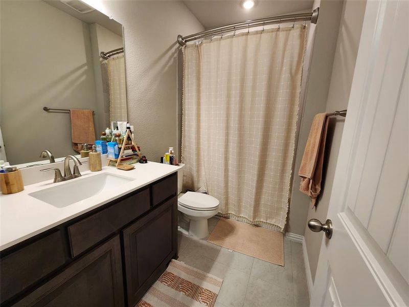 Bathroom 2 featuring tile patterned flooring, a shower with shower curtain, vanity, and toilet