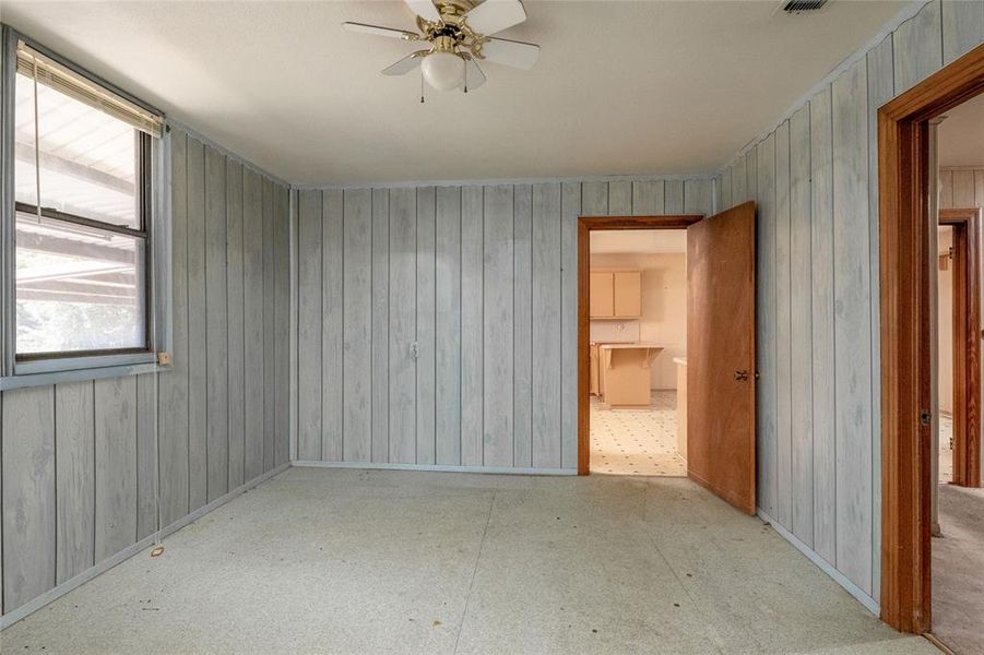 Empty room with wood walls and ceiling fan