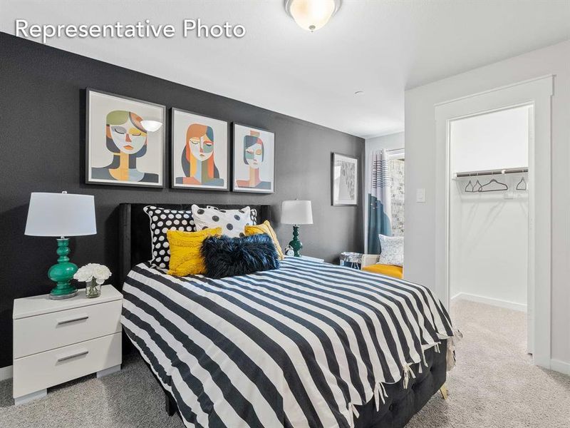 Carpeted bedroom with a walk in closet and a closet