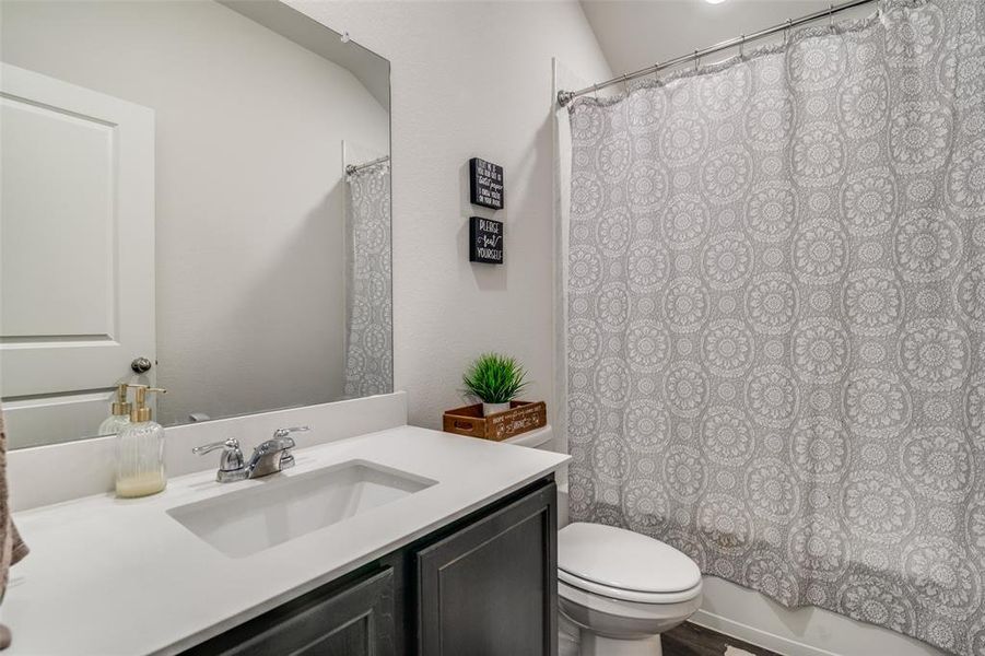 Full bathroom with vanity, toilet, and shower / bathtub combination with curtain