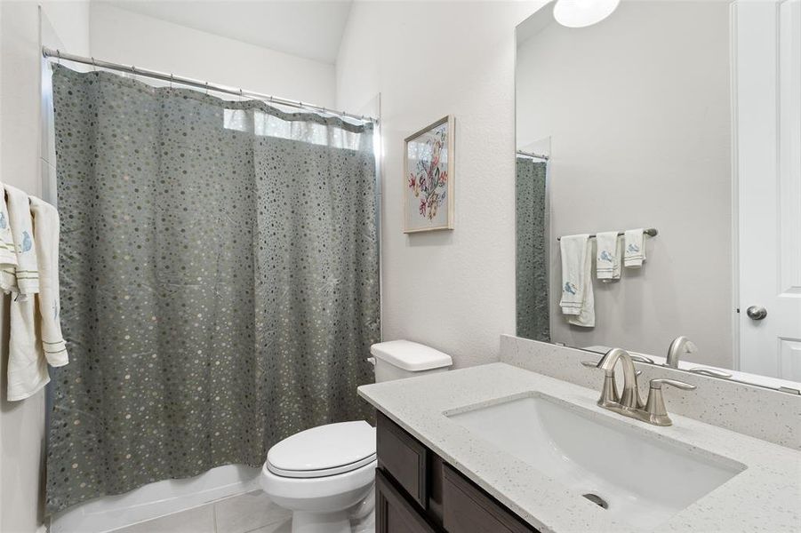 Charming guest bathroom featuring a combination shower/bathtub and a stylish vanity with ample sink space.