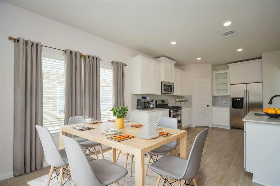 The chef’s kitchen is equipped with stainless steel appliances, elegant white cabinetry, and ample counter space. Large windows allow natural light to pour in, making this kitchen not just functional but a beautiful space to prepare meals. The open layout ensures that the kitchen is connected to the living and dining areas.