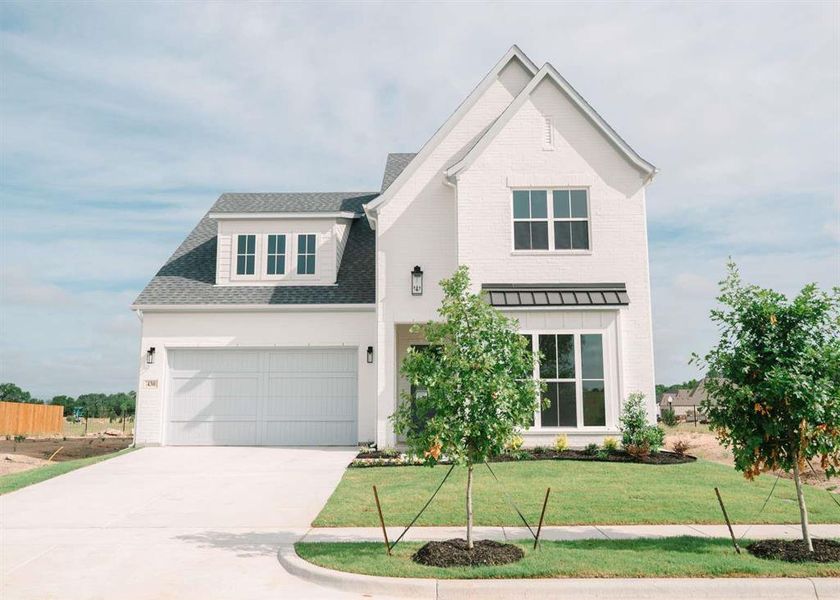 View of front of property featuring a front yard and a garage