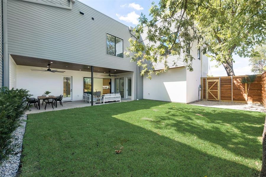 Rear view of property featuring a patio, ceiling fan, and a yard