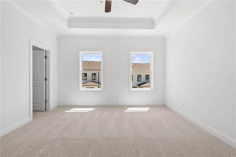 Primary Bedroom with trey ceiling and ceiling fan