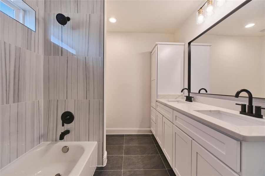 Bathroom with vanity, tiled shower / bath combo, and tile patterned floors