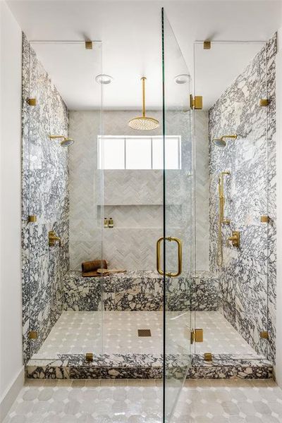 Stunning Calcatta polished marble surround the shower for a striking finish.