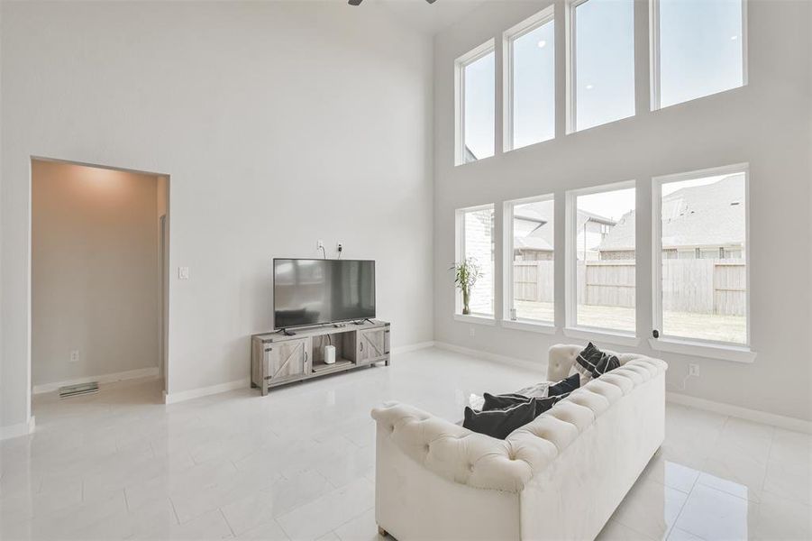 This is a bright, spacious living room with high ceilings and large windows providing ample natural light.