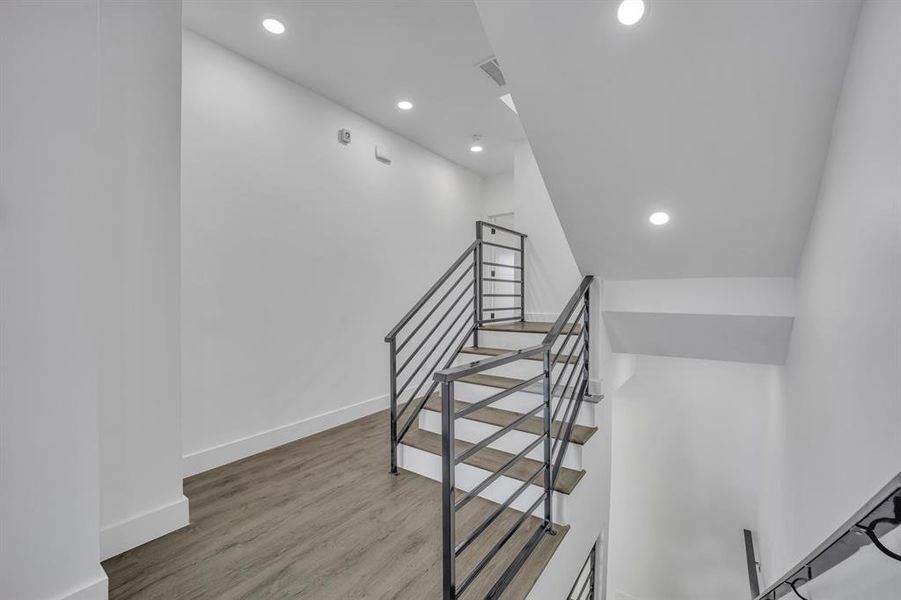 Staircase featuring hardwood / wood-style floors and vaulted ceiling