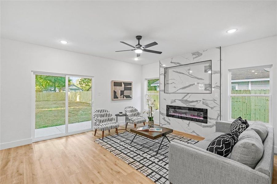 Living room featuring hardwood / wood-style floors, a high end fireplace, and ceiling fan