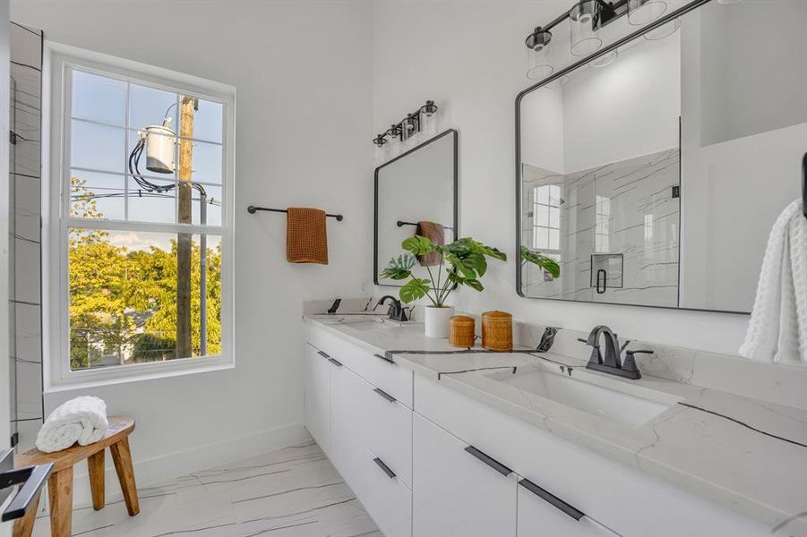 Bathroom with a healthy amount of sunlight, vanity, and a shower with shower door