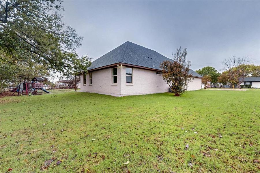 View of side of home with a lawn and a playground