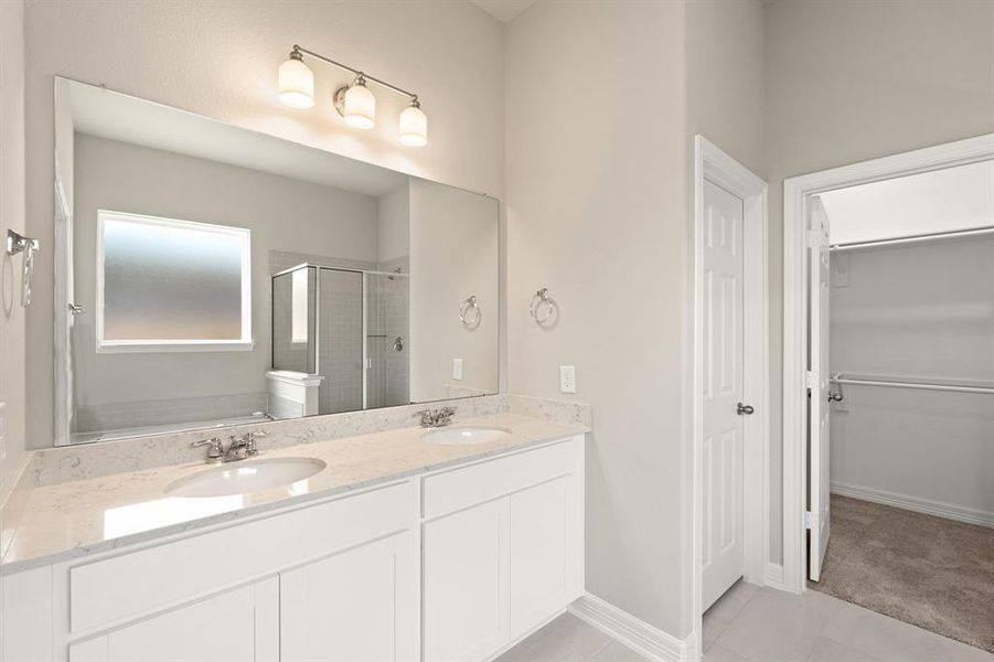 The en-suite bathroom offers a spa-like atmosphere with its elegant design, high end finishes, and tasteful lighting, creating a retreat within your own home.