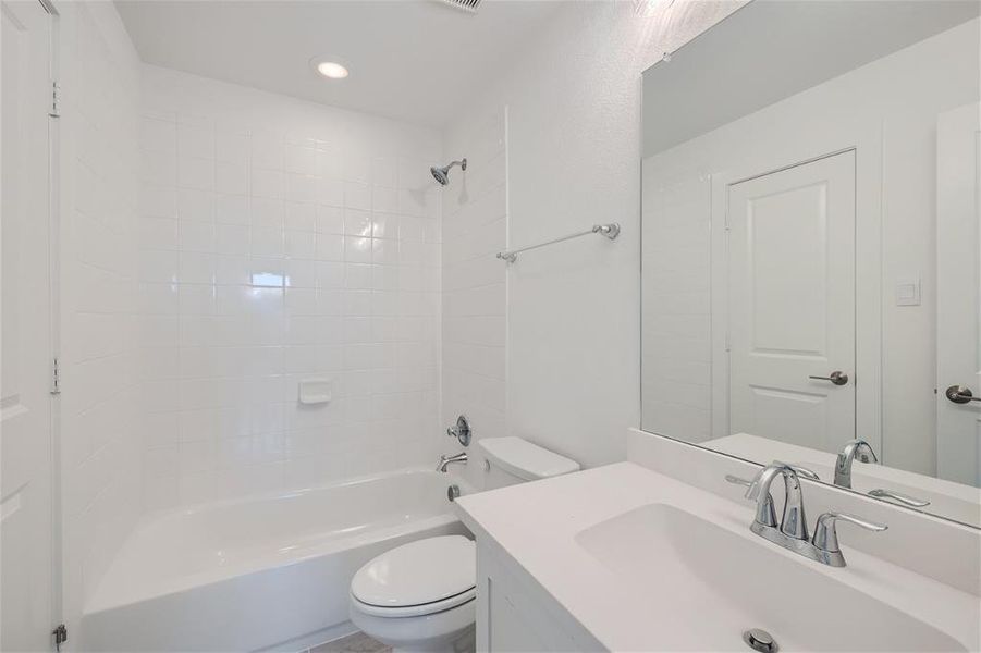 Full bathroom with vanity, toilet, and tiled shower / bath