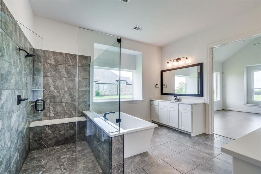 Bathroom featuring tile floors, a wealth of natural light, and vanity