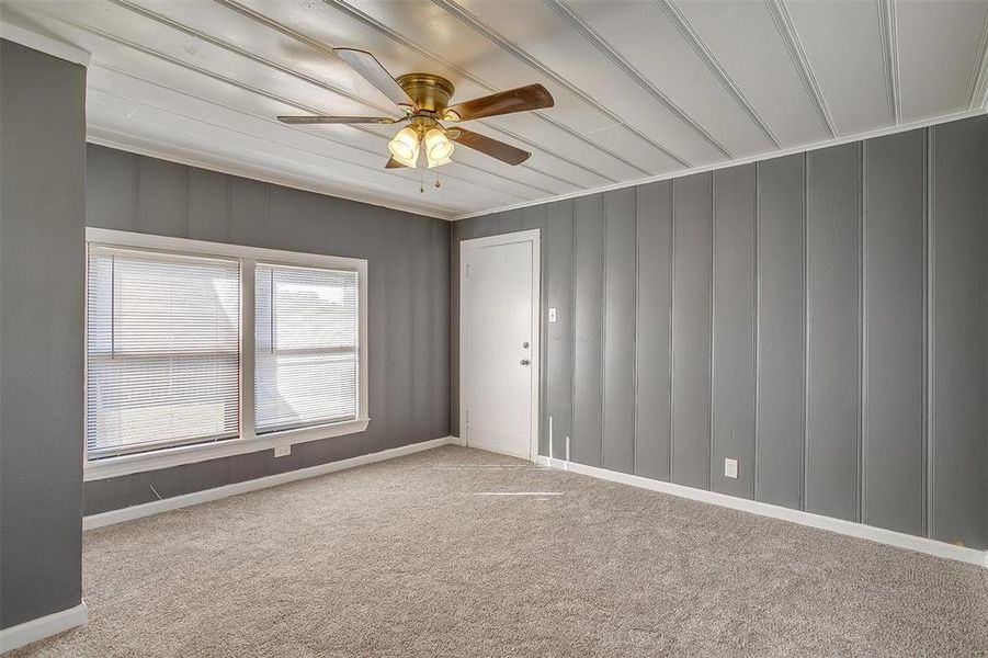 Carpeted empty room with crown molding and ceiling fan