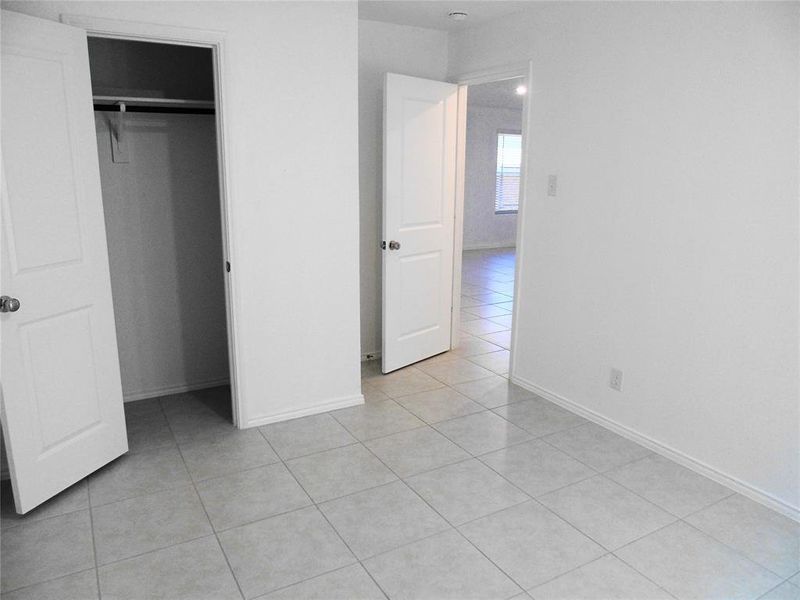 Unfurnished bedroom featuring a closet and light tile patterned flooring