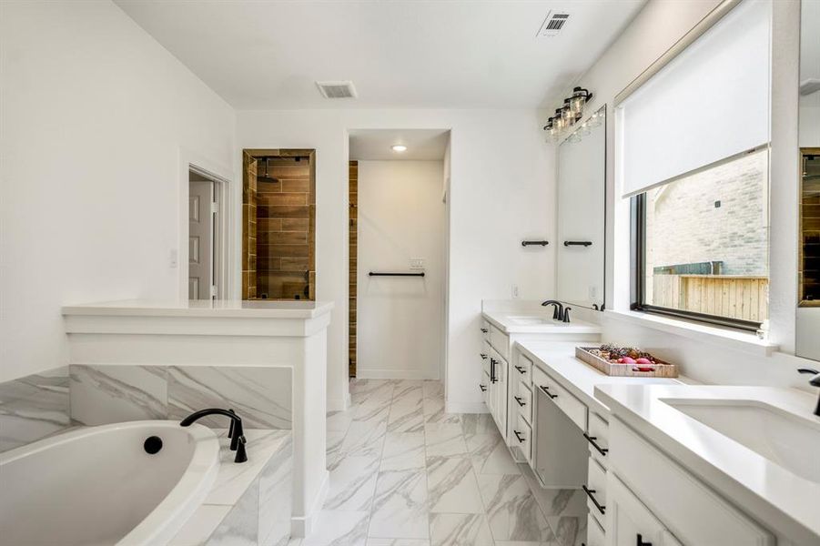 Whether you need a quick shower to start your day or a relaxing bath to end one, this bathroom has just what you need! The spacious shower includes an upgraded tile surround extended to the ceiling, rain showerhead, frameless glass entry, and window letting in natural light.