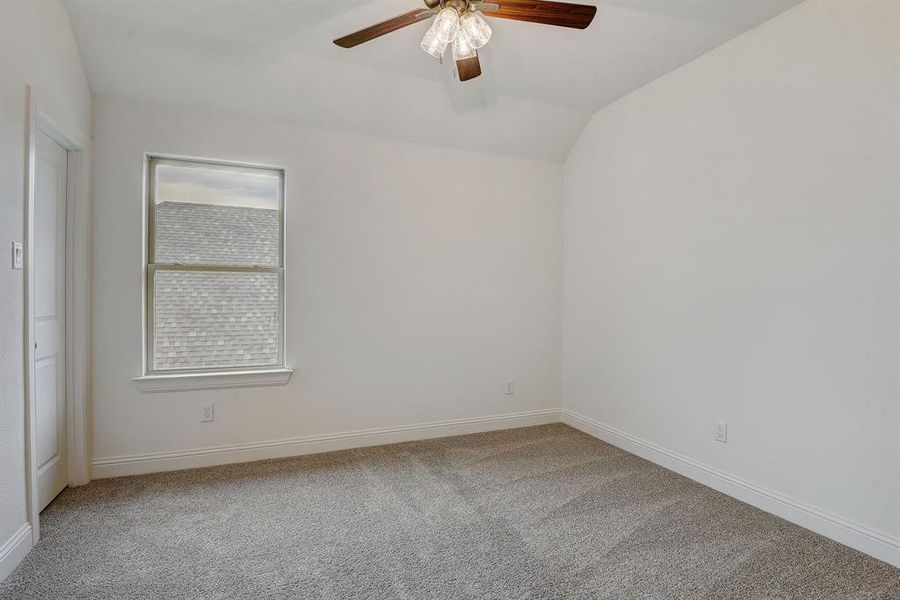 Unfurnished room with carpet flooring, vaulted ceiling, and ceiling fan