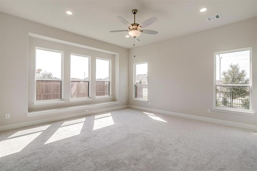 Carpeted spare room with ceiling fan