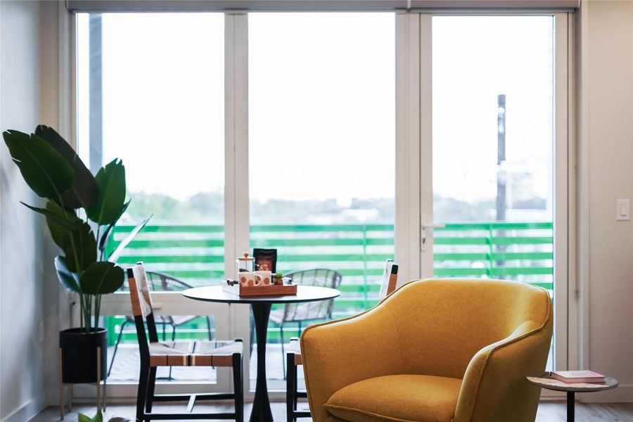 Natural light streams through the large windows into the living space and kitchen.