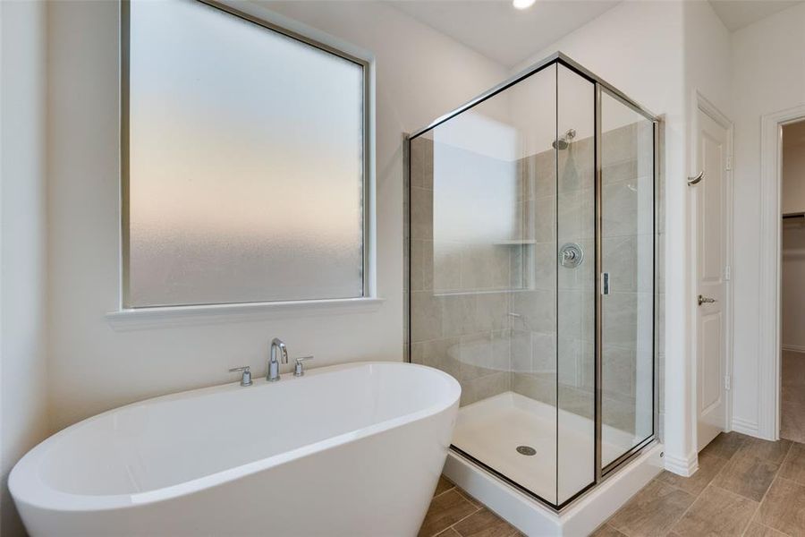 Bathroom featuring shower with separate bathtub and wood-type flooring