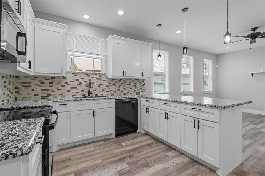 Kitchen with white cabinets, light hardwood / wood-style floors, stainless steel appliances, tasteful backsplash, and sink