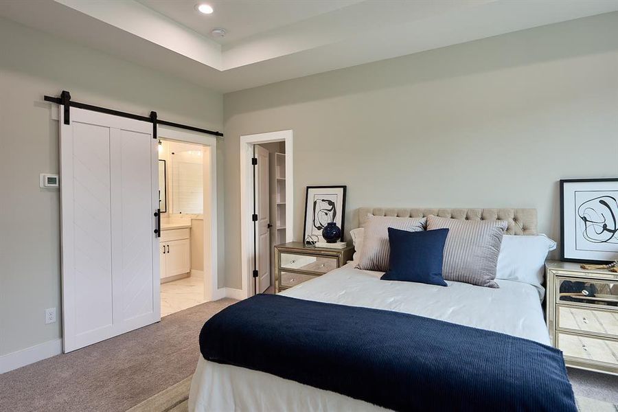 Large primary bedroom with elegant sliding barn door.