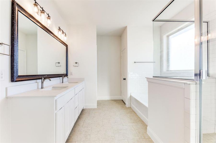 Bathroom featuring tile patterned flooring, vanity, and plus walk in shower