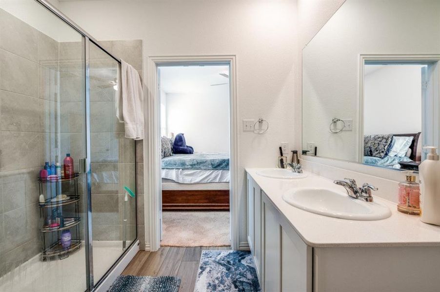 Bathroom featuring wood-type flooring, vanity, and a shower with shower door