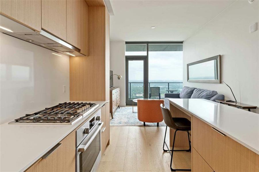 Gourmet kitchen open to living area with skyline views