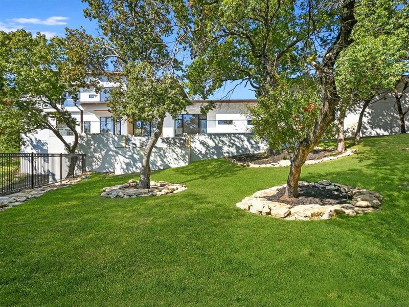 The outdoor living spaces enhance the entertainment aspect of the house, complemented by an enormous negative-edge pool and a fully equipped outdoor kitchen.