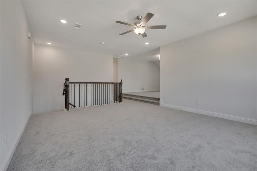 Carpeted spare room with ceiling fan