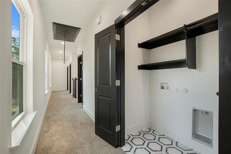 Hallway featuring light colored carpet