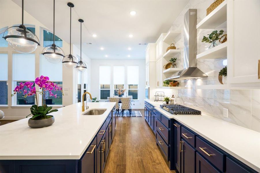 Kitchen featuring white cabinets, island exhaust hood, a center island with sink, dark wood-type flooring, and sink