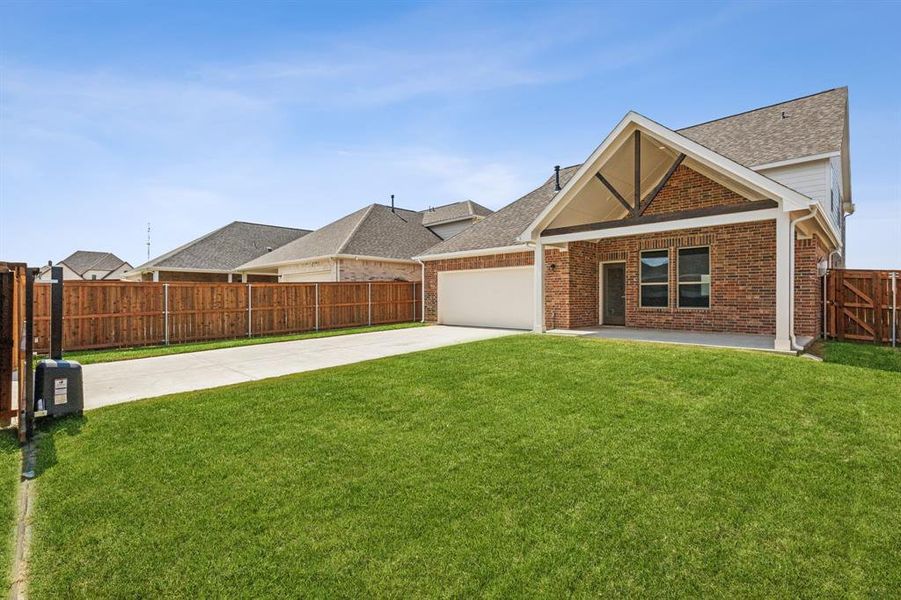 View of front facade with a garage, a front yard, and a patio area