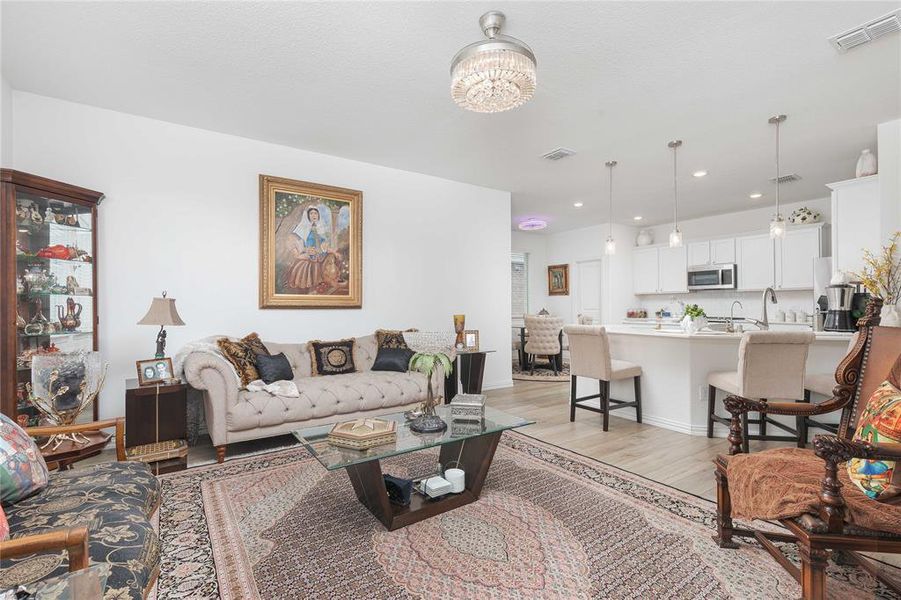 Living room with a notable chandelier and light hardwood / wood-style floors