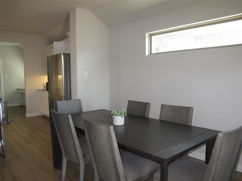 Dining room with lofted ceiling and dark wood-type flooring