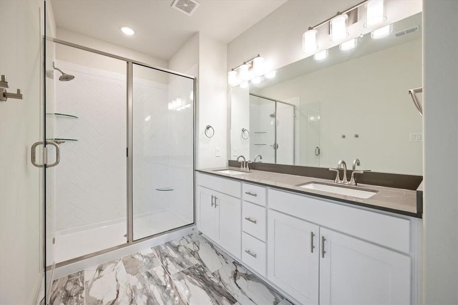 Featuring an oversized walk in shower and double vanity, this owner's bath offers plenty of space for two!