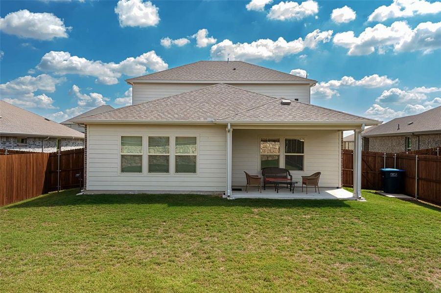 Back of property featuring a yard and a patio