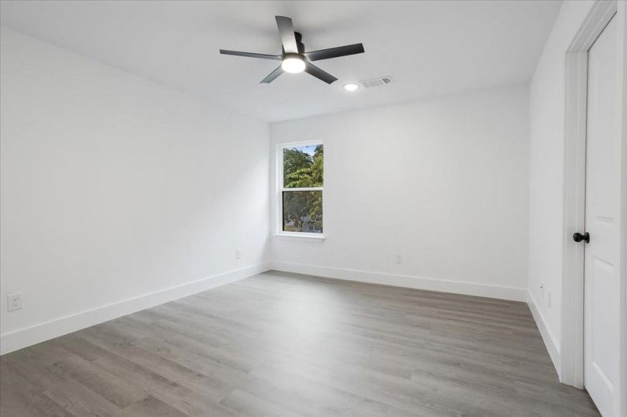 Empty room featuring light wood-type flooring and ceiling fan