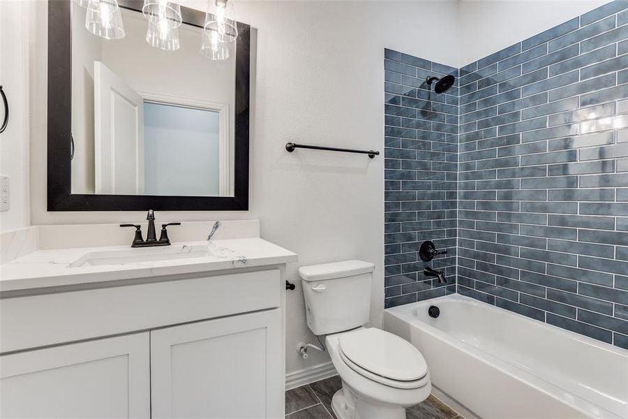 Full bathroom with toilet, vanity, wood-type flooring, and tiled shower / bath