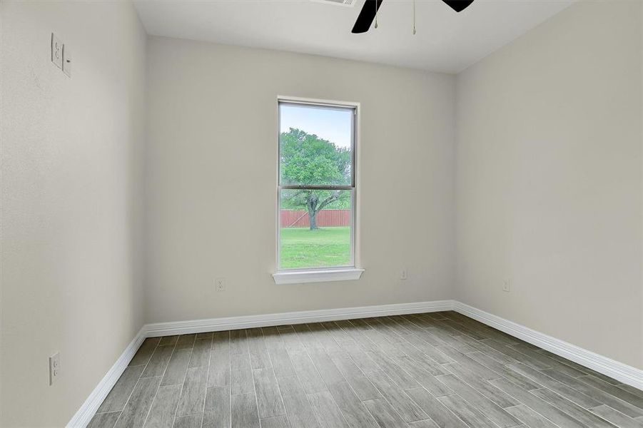 Unfurnished room featuring Tile Plank flooring, ceiling fan, and plenty of natural light