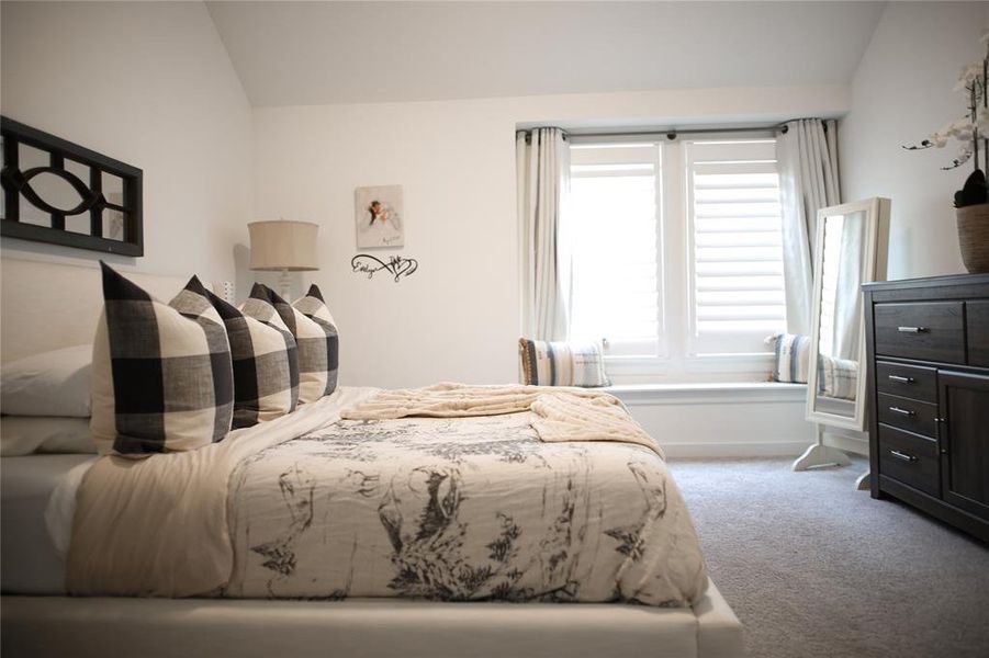 Bedroom with carpet flooring and vaulted ceiling